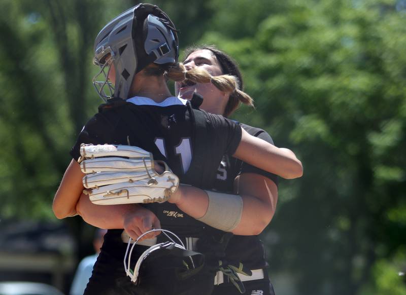Prairie Ridge’s Reese Mosolino embraces catcher Kendra Carroll after the final out of a win over Harvard during Class 3A softball regional final action at Lions Park in Harvard Saturday.