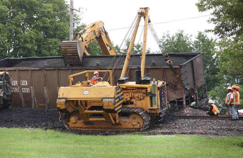 A crane moves into position to finish uprighting a coal car of a BNSF Railway train after it derailed Wednesday, July 10, 2024, near Route 34 on the west side of Somonauk.