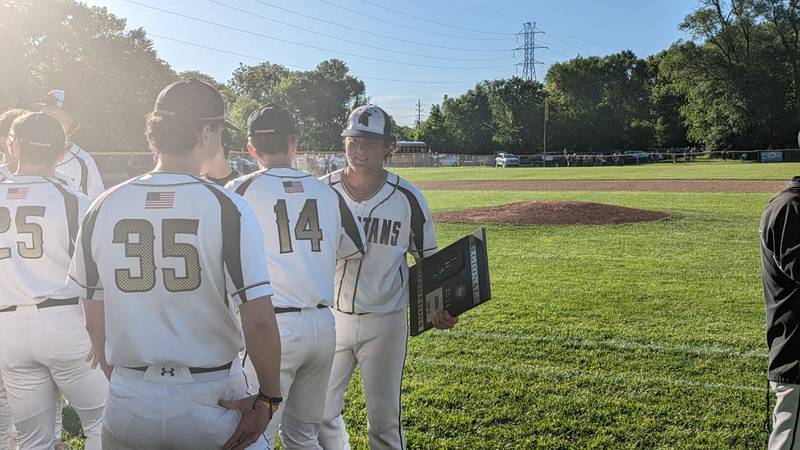 Sycamore third baseman Matt Rosado celebrates with teammates while holding the championship plaque after Sycamore's 4-3, eight-inning win against Dixon on Saturday in the Class 3A Dixon Regional championship.