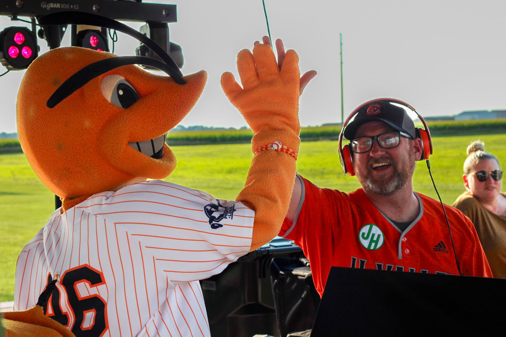 Illinois Valley Pistol Shrimp mascot Southclaw high-fives the "Guys on the Radio DJ" on Thursday, Aug. 1, 2024, at Schweickert Stadium at Veterans Park in Peru.