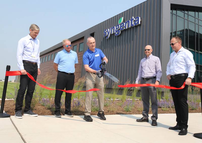 Warren Kruger, head of field crops seeds development for North Americaat Syngenta, cuts the ribbon flanked by Erik Fyrwald, (l-r) chief executive officer for the Syngenta Group, Eric Boeck, head of marketing for Syngenta Seeds, Trevor Hohls, global head of seeds development and Justin Wolfe, president of Syngenta Seeds Friday, June 23, 2023, during the grand opening of the Syngenta Seeds Research and Development Innovation Center in Malta.