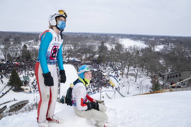 Ski jumpers Connor Swanson, left, with his brother Payton, of Grand Rapids, Minnesota, watch the competition as they jump during the 117th annual Norge Winter Ski Jump Tournament on Sunday, Jan. 30, 2022 in Fox River Grove.