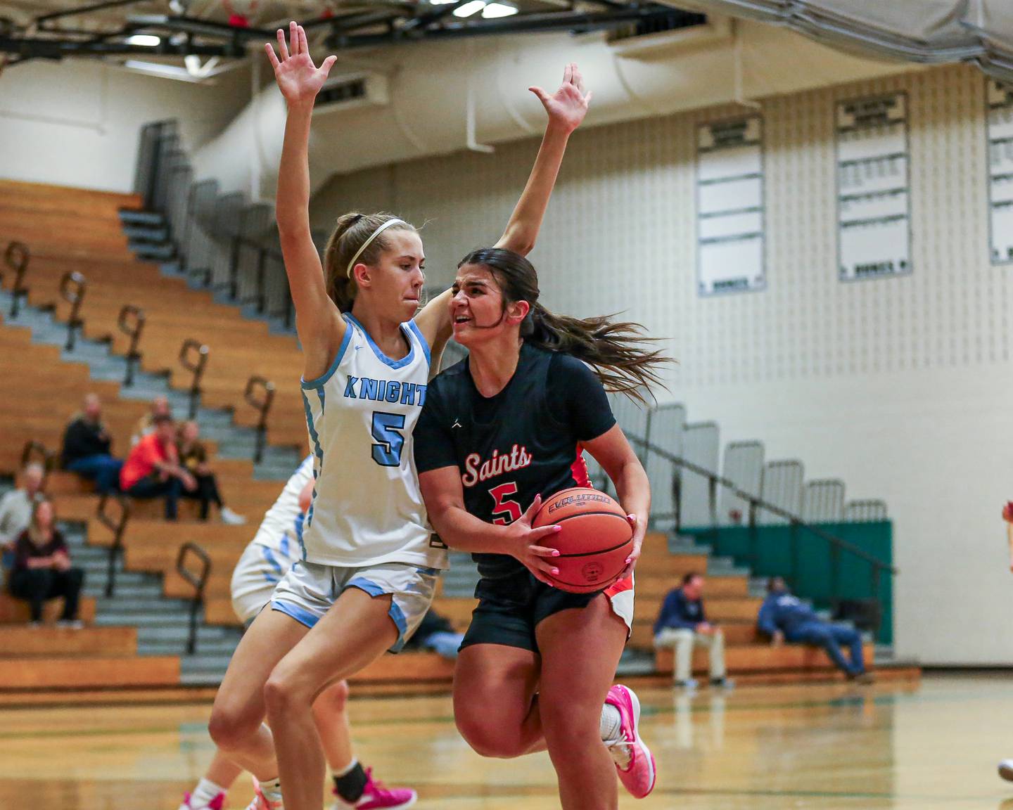 St Charles East's Lexi DiOrio (5) is defended by Prospect's Colleen Shute (5) while driving to the hoop at the York Thanksgiving Tournament. Nov 13, 2023.