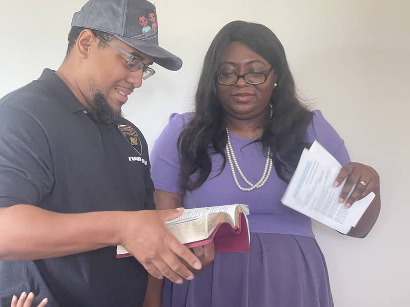 Carmelo Gonzalez (left) and wife Leah Gonzalez recite scripture from the Bible on Sunday, May 19, 2024, during a house dedication and blessing for the Gonzalez family, put on by Habitat for Humanity of DeKalb County in Kingston.