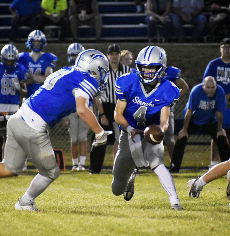 Woodstock quarterback Caden Thompson hands off to running back Landen Stoltz in their game against Rochelle on Friday.