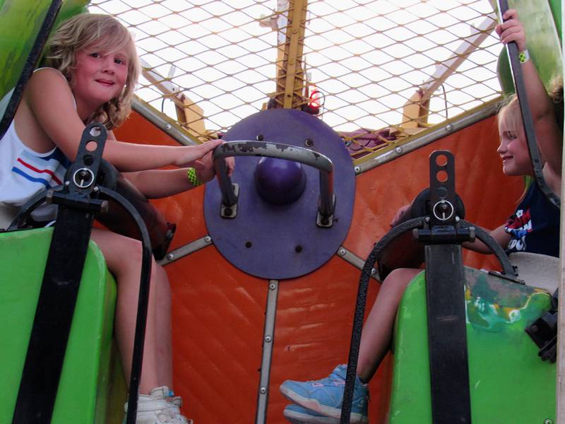 Wyatt and Gwen King sit on a carnival ride Wednesday at the Grundy County Fair.