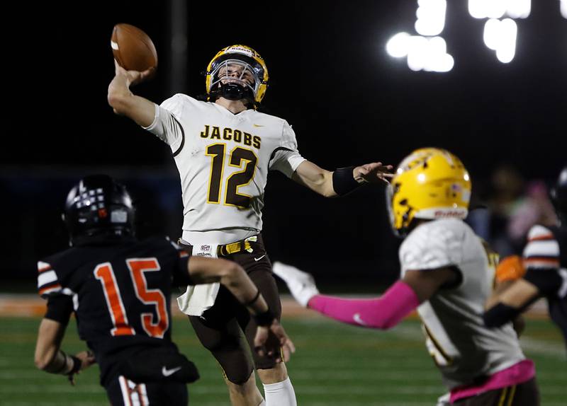 Jacobs' Connor Goehring throws a pass over the rush of McHenry's James Butler during a Fox Valley Conference football game on Friday, Oct. 18, 2024, at McKracken Field in McHenry.