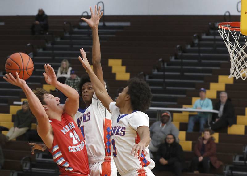 Marian Central's Christian Bentancur drives to the basket against Hoffman Estates’ DJ Wallace (center) and Trendell Whiting (right) during a Hinkle Holiday Classic basketball game Tuesday, Dec. 27, 2022, at Jacobs High School in Algonquin.