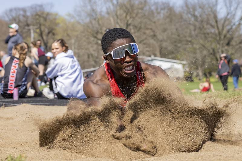 Jordan Lukes makes impact with the sand after achieving an 11.75 meter triple jump for Streator High School during the Rollie Morris Invite at Hall High School on April 13, 2024.