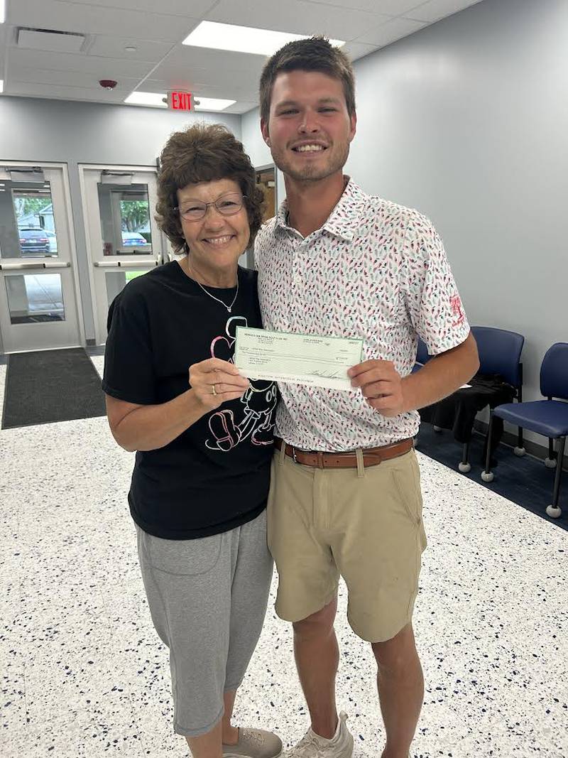 Jessica Kreiser of Lighted Way accepts a check from Nate Rodriguez of Senica's Oak Ridge following the Senica Six six-man scramble Saturday, July 6, 2024.