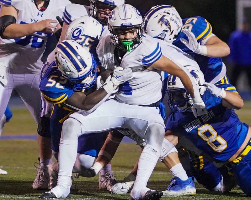 Wheaton North's John Tarpeh (52) tackles Geneva’s Troy Velez (4) in the backfield for loss late in the 4th quarter of play against Geneva during a football game at Wheaton North High School on Friday, Oct. 6, 2023.