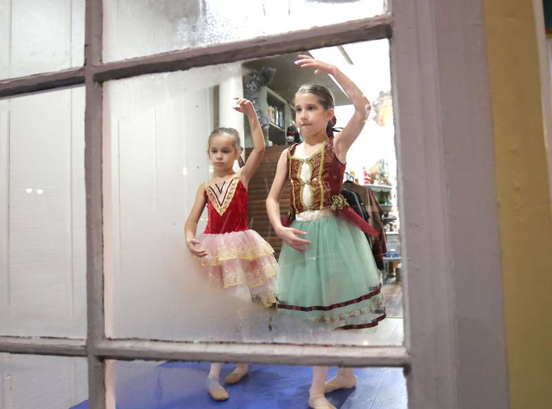 Adelyn Cordes, (left), and Everly Johnson, both from DeKalb dance in the window of Blu Door Decor Friday, Nov. 12, 2021, during the Second Fridays event, themed “Tinsel and Traditions.”