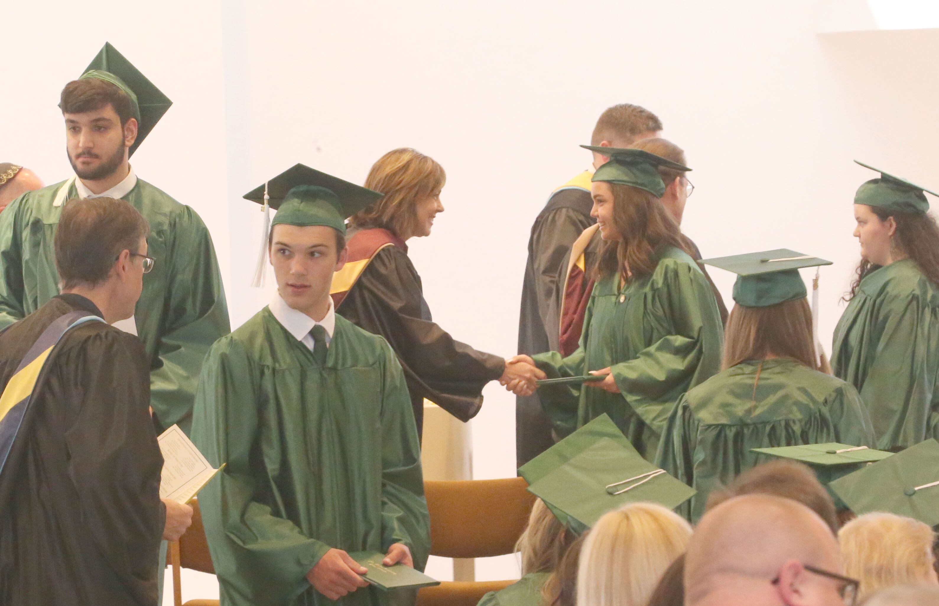 St. Bede graduates receive their diplomas during the Class of 2023 graduation ceremony on Sunday, May 21, 2023, in the Abbey Church at the academy.