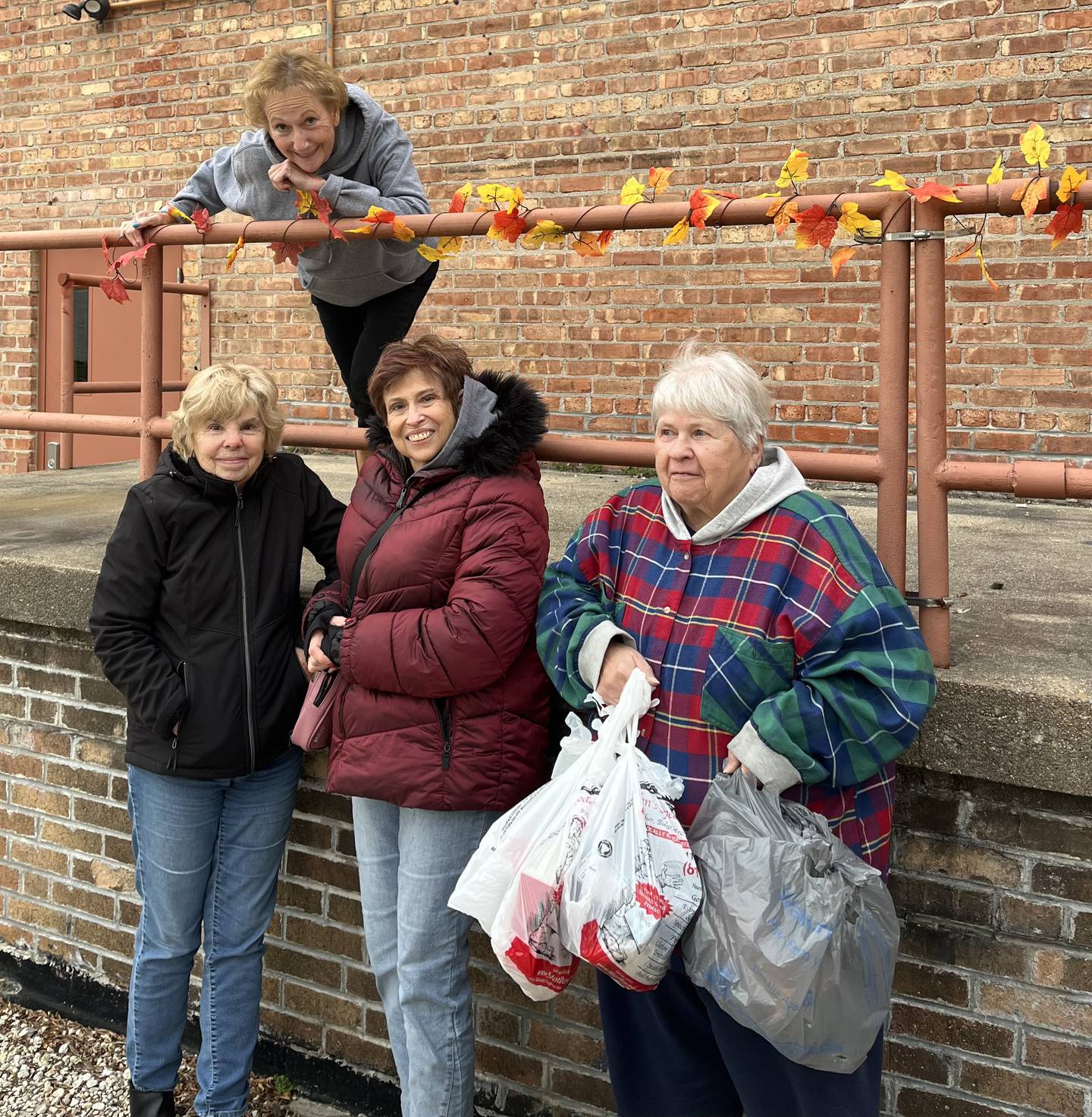 Jan Kuntz stands above Judy O'Connor, Roberta Maxfield and Linda Ball during one of the drop of times for the Stage Coach Players Thanksgiving Food Drive.