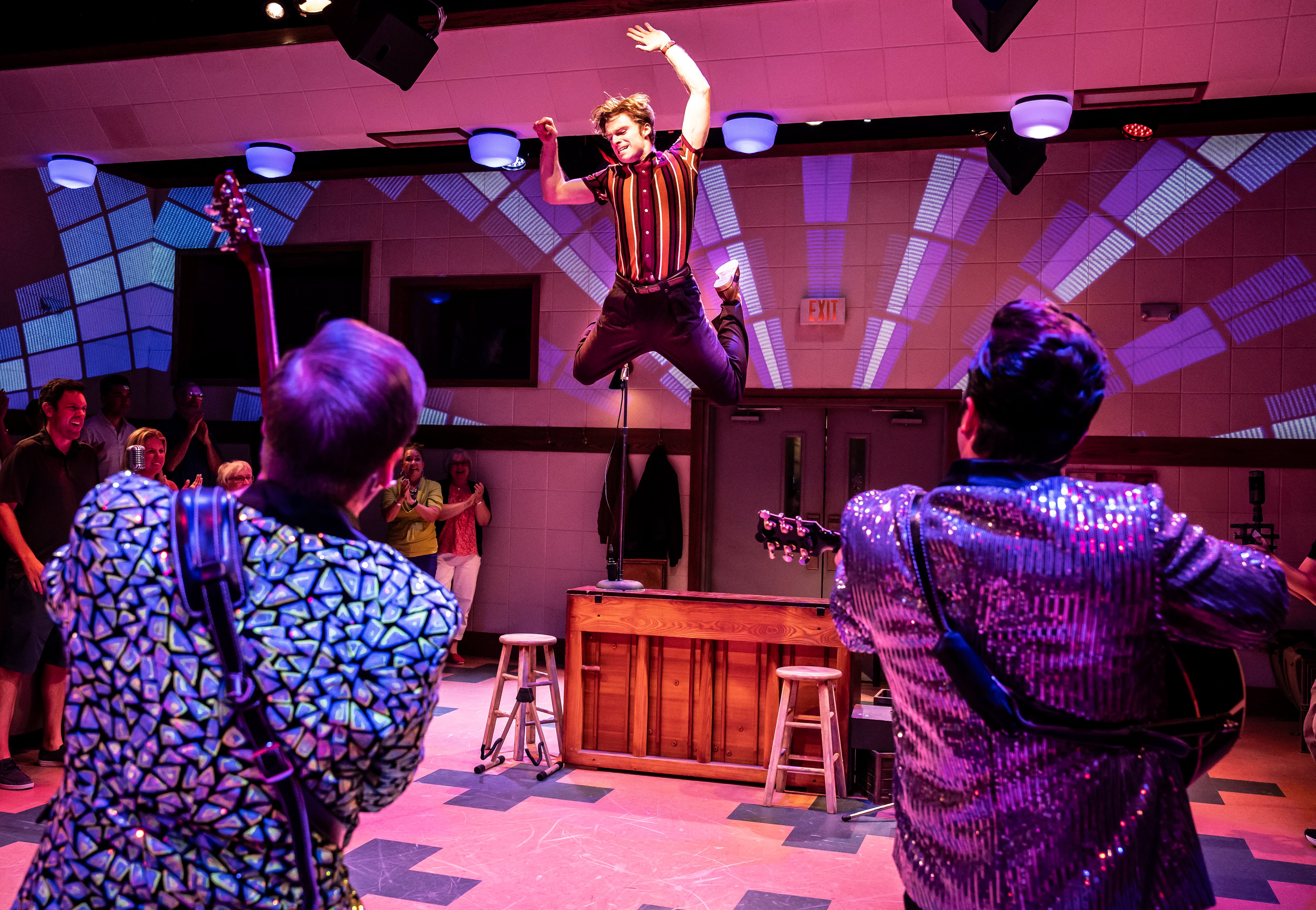 Garrett Forrestal (center) plays Jerry Lee Lewis in Million Dollar Quartet, the inaugural production at Paramount Theatre’s new Stolp Island Theatre, 5 E. Downer Place, Suite G, in downtown Aurora. Performances have already been extended through December 29, 2024 due to popular demand. Also pictured (backs to camera, from left): Christopher Wren as Carl Perkins and Bill Scott Sheets as Johnny Cash. Tickets: paramountaurora.com or (630) 896-6666. Credit: Liz Lauren