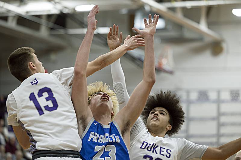 Dixon’s Cullen Shaner (left) and Dixon’s Darius Harrington works against Princeton’s Noah Laporte Thursday, Dec. 21, 2023 at Dixon High School.