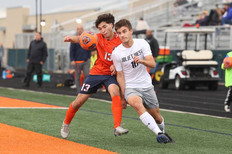 Joliet West’s Tommy Polacek stays with the ball despite the charge of Romeoville’s Ruben Mesta on Wednesday, Oct. 11, 2023 in Romeoville.