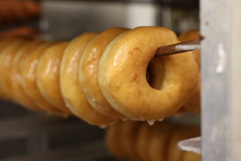 Glazed donuts, a customer favorite, hang on a rack at Home Cut Donuts on Jefferson Street, Saturday, March 25, 2023 in Joliet.