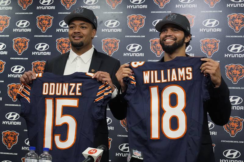 Chicago Bears No. 9 draft pick wide receiver Rome Odunze, left, and No. 1 draft pick quarterback Caleb Williams, right, hold up jerseys as they pose for a photo during an NFL football news conference in Lake Forest, Ill., Friday, April 26, 2024.