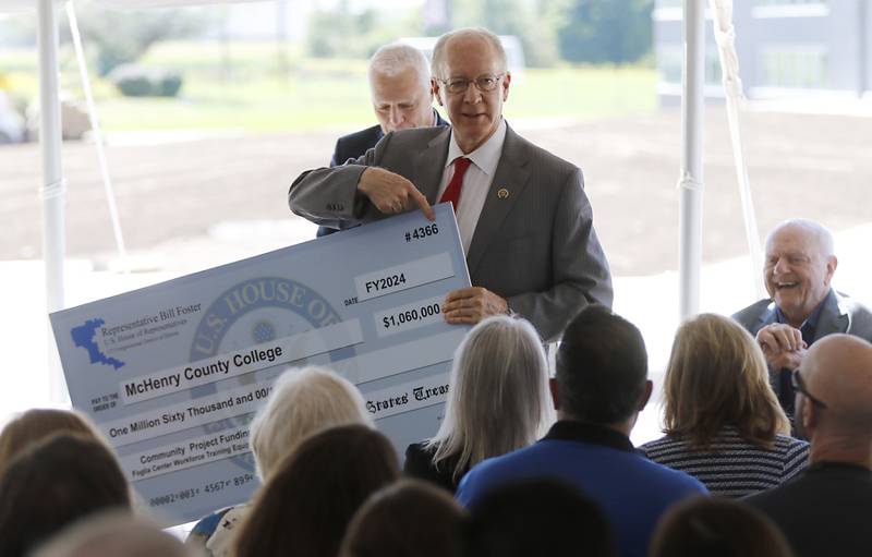 U.S. Rep. Bill Foster, (right) who now represents much of McHenry County shows a giant check while speaking during the opening ceremony for the Foglia Center for Advanced Technology and Innovation on Tuesday, Sept. 3, 2024, at McHenry County College.