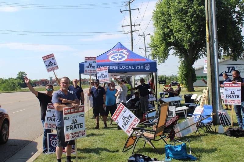 About 50 JA Frate drivers stand outside the Crystal Lake headquarters holding picket signs reading “on strike” after negotiations over a new contract with the company have turned sour.