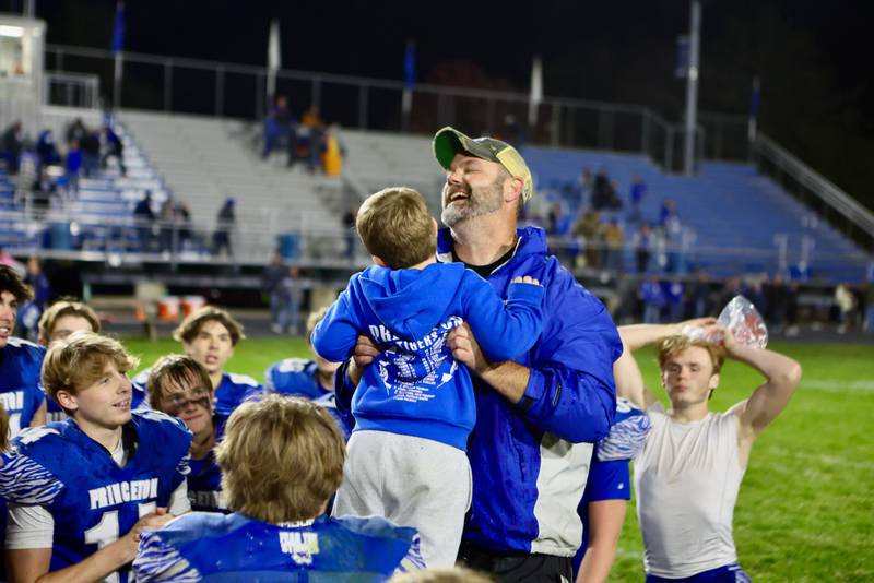 Princeton coach Ryan Pearson celebrates Friday's 57-20 win over Mercer County at Bryant Field with his son, Roman.