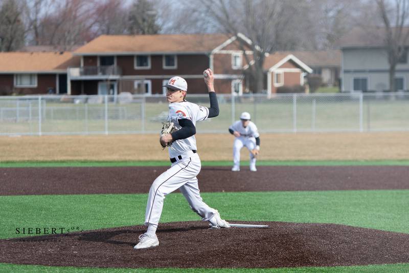 McHenry's Brandon Shannon throws a pitch in the Warriors' opener at their new baseball field last Saturday. McHenry is the only area team with an artificial turf infield.