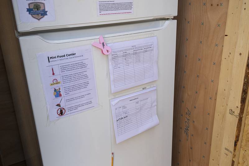 A log sheet is attached to the front of the refrigerator at the Amboy rural mini food mart Thursday, June 20, 2024. The sheet is to record food taken and donated for data purposes. People using the mart do not need to supply any personal information.
