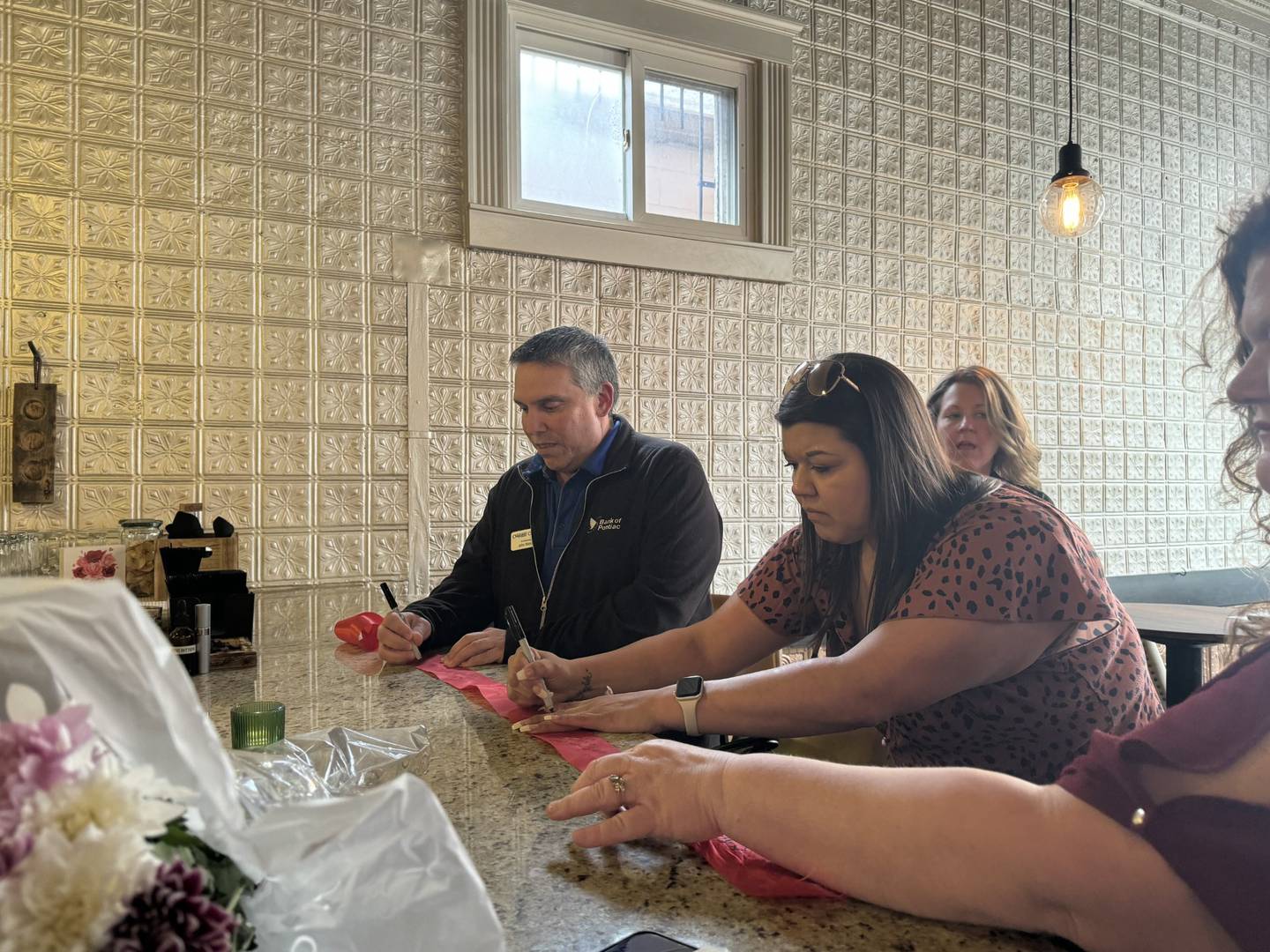 Members of the Minooka-Channahon Chamber of Commerce sign the ribbon before cutting it.