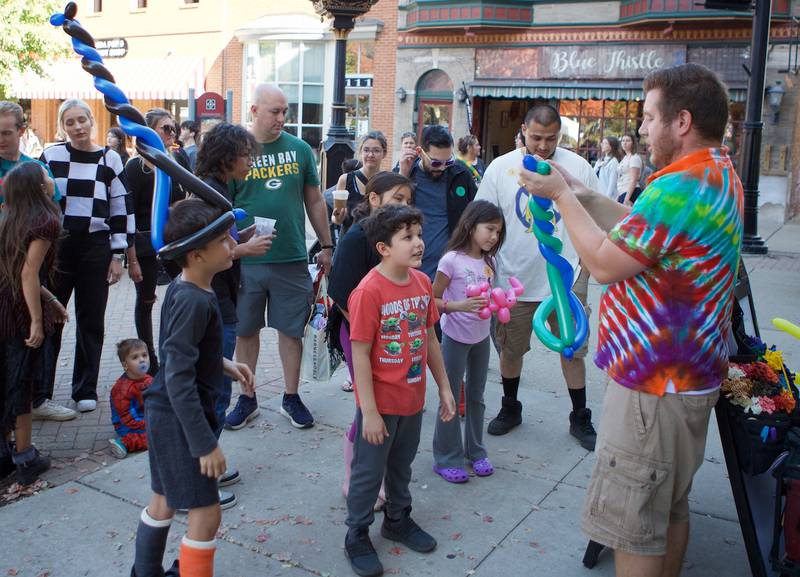 Children watch – and wear his creations – as a balloon artist works his magic at Witches and Wizards of Woodstock on Sunday, Oct. 20, 2024 in Woodstock.