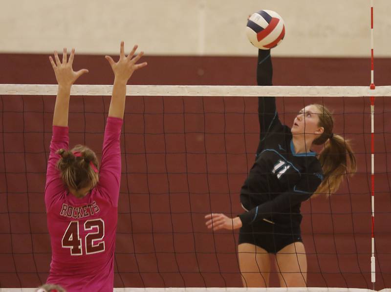 Woodstock North’s Alexis Hansen tries to hit the ball past the block of Richmond-Burton's Zoe Freund during a Kishwaukee River Conference volleyball match Wednesday, Oct.11, 2023, at Richmond-Burton Community High School.