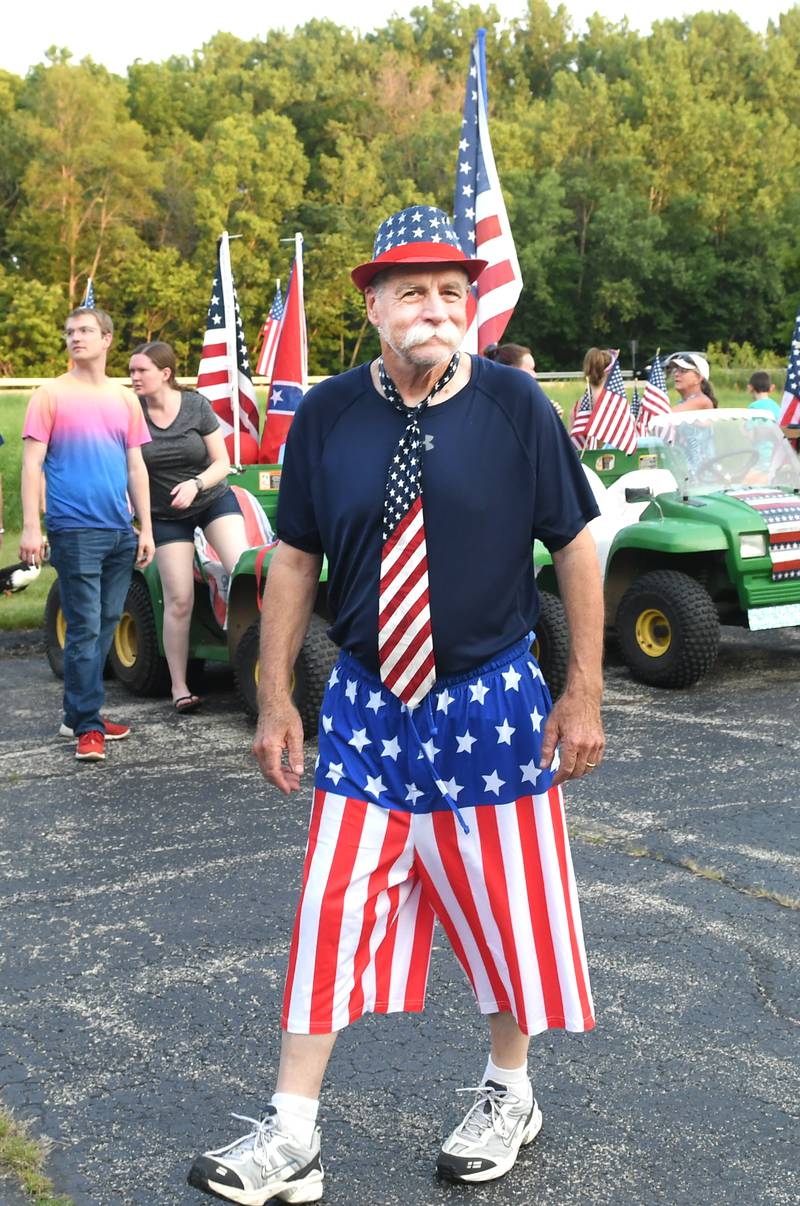 Jim Ross, the master of ceremonies for the Grand Detour Golf Cart Parade looks over this year's entries prior to the start of the event.