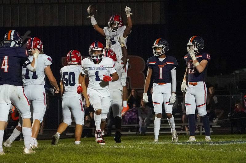 West Aurora's Michael Williams (5) is lifted into the air after scoring a touchdown against West Aurora during a football game at Oswego High School on Friday, Sept. 29, 2023.