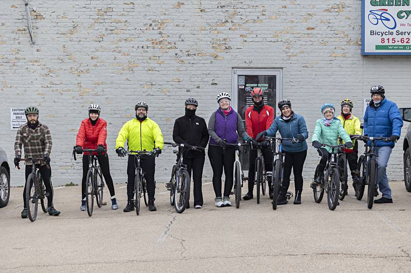 Cyclists Julian Rodriguez (left), Becky Shemaker, Shane Miller, Rachelle Yore, Annie Adkins, Ken Couperus, Dawn Moore, Teagan Moore, Pam Fenwick and Matt Moore line up before taking off on the ride Monday, Jan. 1, 2024.