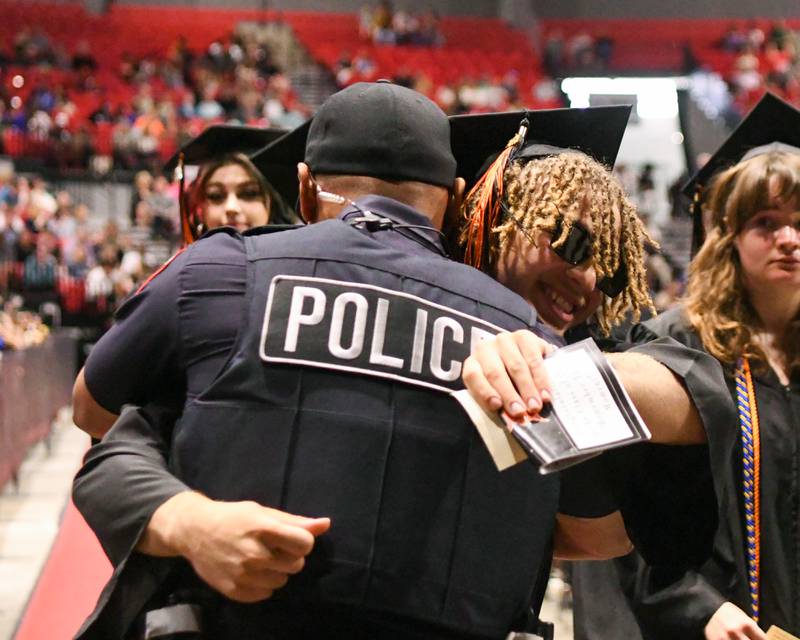 Talen Tate gets a hug from his godfather and NIU police officer, Daniel Mojica, during the DeKalb High School 2024 Commencement held at the NIU Convocation Center in DeKalb.