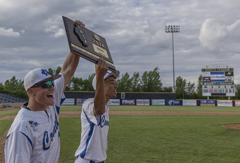 Newman’s Brendan Tunink (left) and Isaiah Williams celebrate with the super-sectional plaque Monday, May 27, 2024 during the Class 2A super-sectional in Rockford. The Comets beat Chicago Hope 6-2.