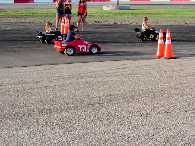 Brylee Corcoran (right) crosses the finish line with a slim lead during the Kids' Power Wheel race.