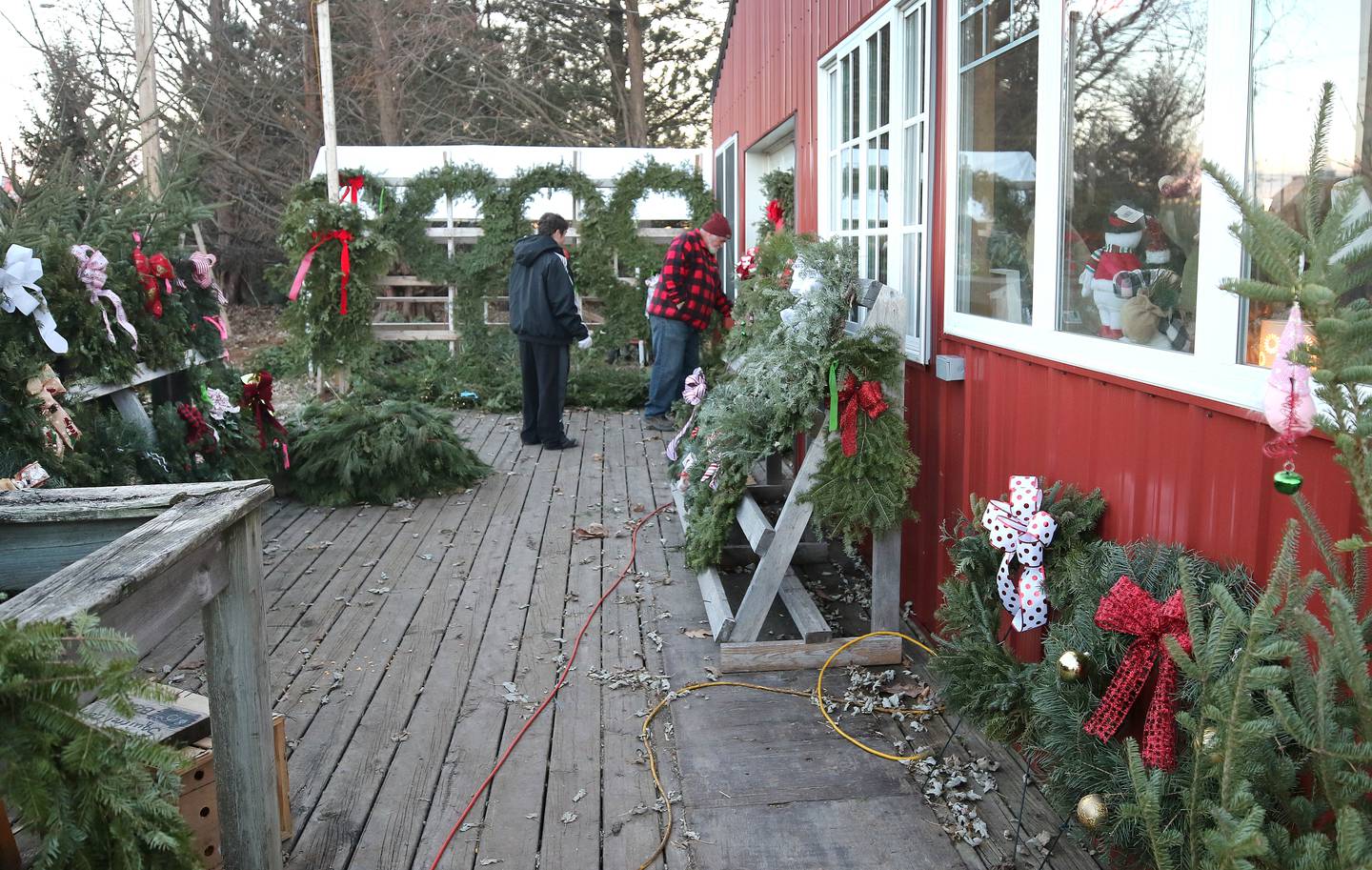 Rob Wessels, owner of Wessels' Family Farm, and his grandson Davey Wessels, 17, from South Paris, Maine, work on the deck Tuesday, Dec. 12, 2023, at Wessels' Family Farm Market in DeKalb.