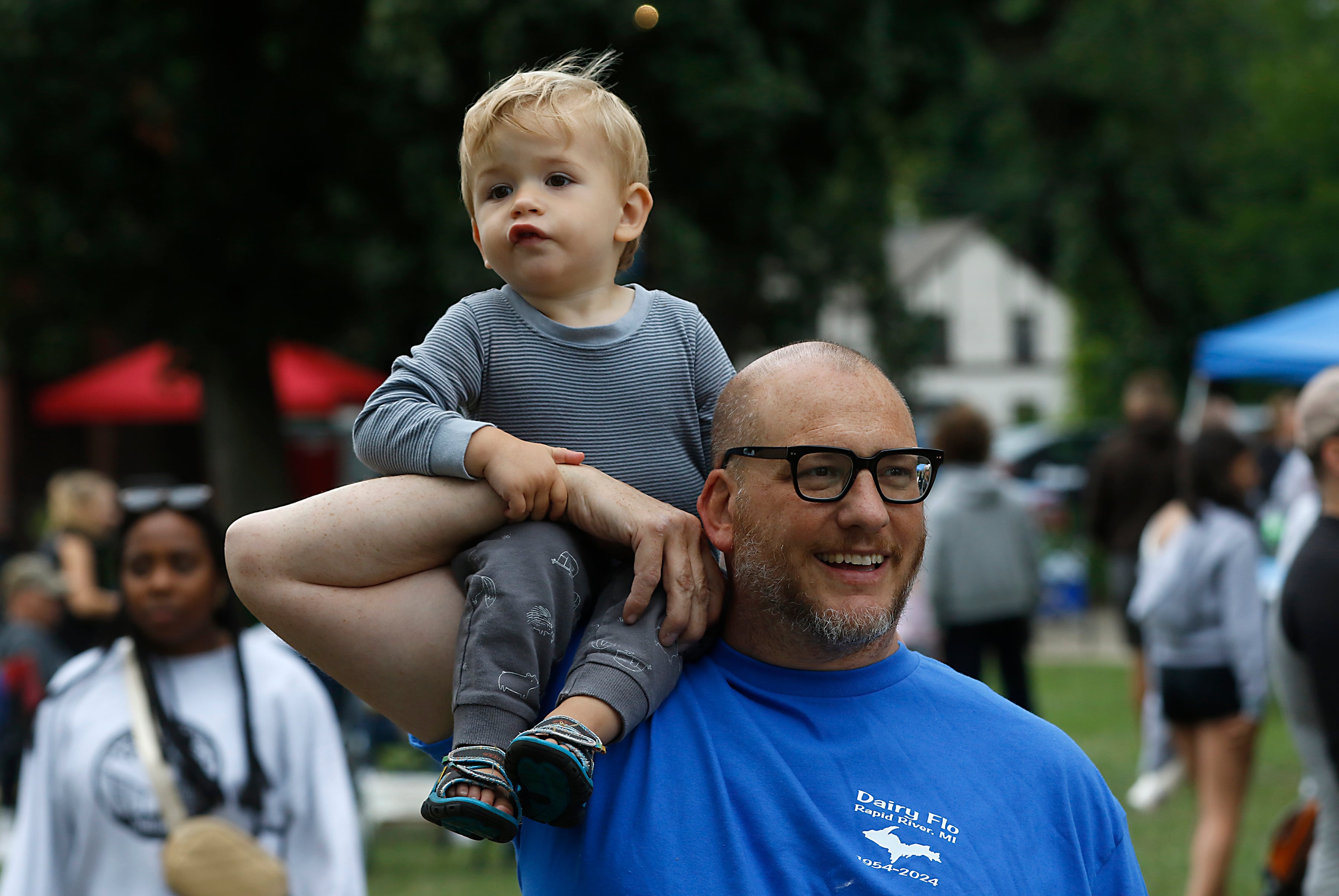 Magnus Schweitzer, 21 months, rides on the shoulder of his dad, Ed, as they walk around the Ice Cream Fest on Friday, Aug. 9, 2024, at Crystal Lake’s Main Beach.  The second annual event featured music, ice cream venders and an ice cream eating contest.