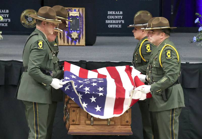 Illinois State Police officers remove the flag from the casket of DeKalb County Sheriff’s Deputy Christina Musil to give to her family Thursday, April 4, 2024, during her visitation and funeral in the Convocation Center at Northern Illinois University. Musil, 35, was killed March 28 while on duty after a truck rear-ended her police vehicle in Waterman.
