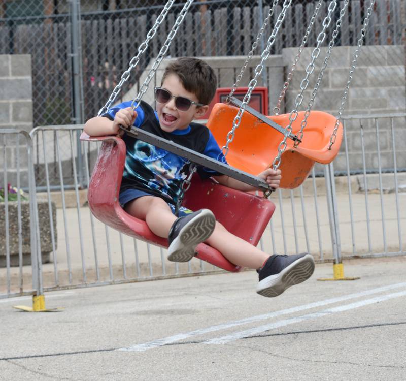 Isco gonzalez, 5, of Dixon, smiles at his dad as he takes a spin on a carnival ride at Town & Country Days in Polo on Saturday, June 15, 2024.