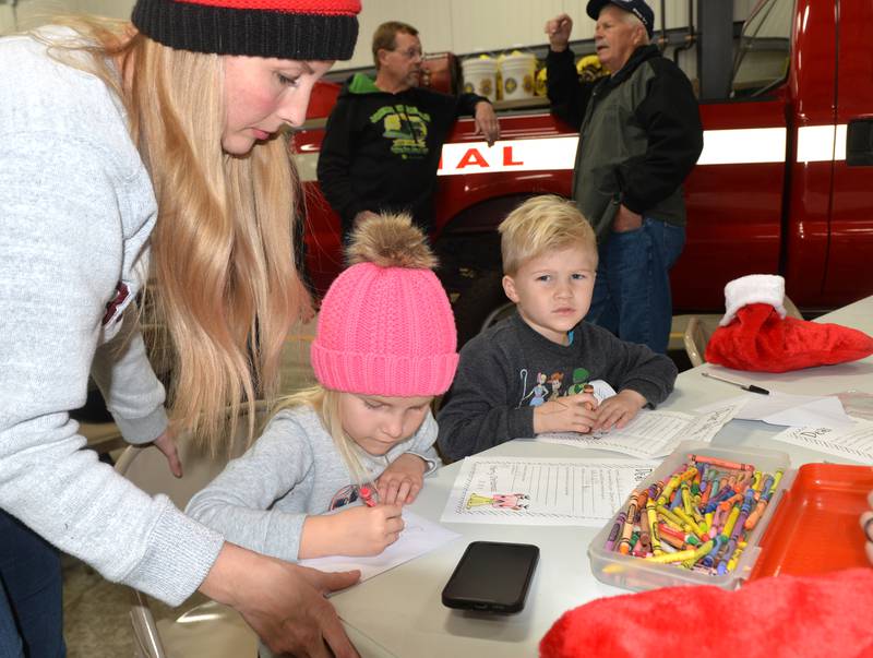 Rosalee Tenbor, 3, of Erie, and her mom Karlie, work on her letter to Santa along with her brother, Anthony, 4, during Erie's Hometown Holidays on Saturday, Dec. 2, 2023. Letter writing was one of the kids activities at the Erie Fire Station.