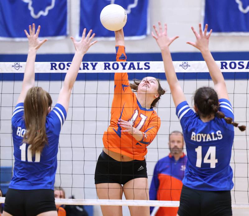 Genoa-Kingston's Lily Mueller spikes the ball past two Rosary blockers during their Regional semifinal match Tuesday, Oct. 25, 2022, at Rosary High School in Aurora