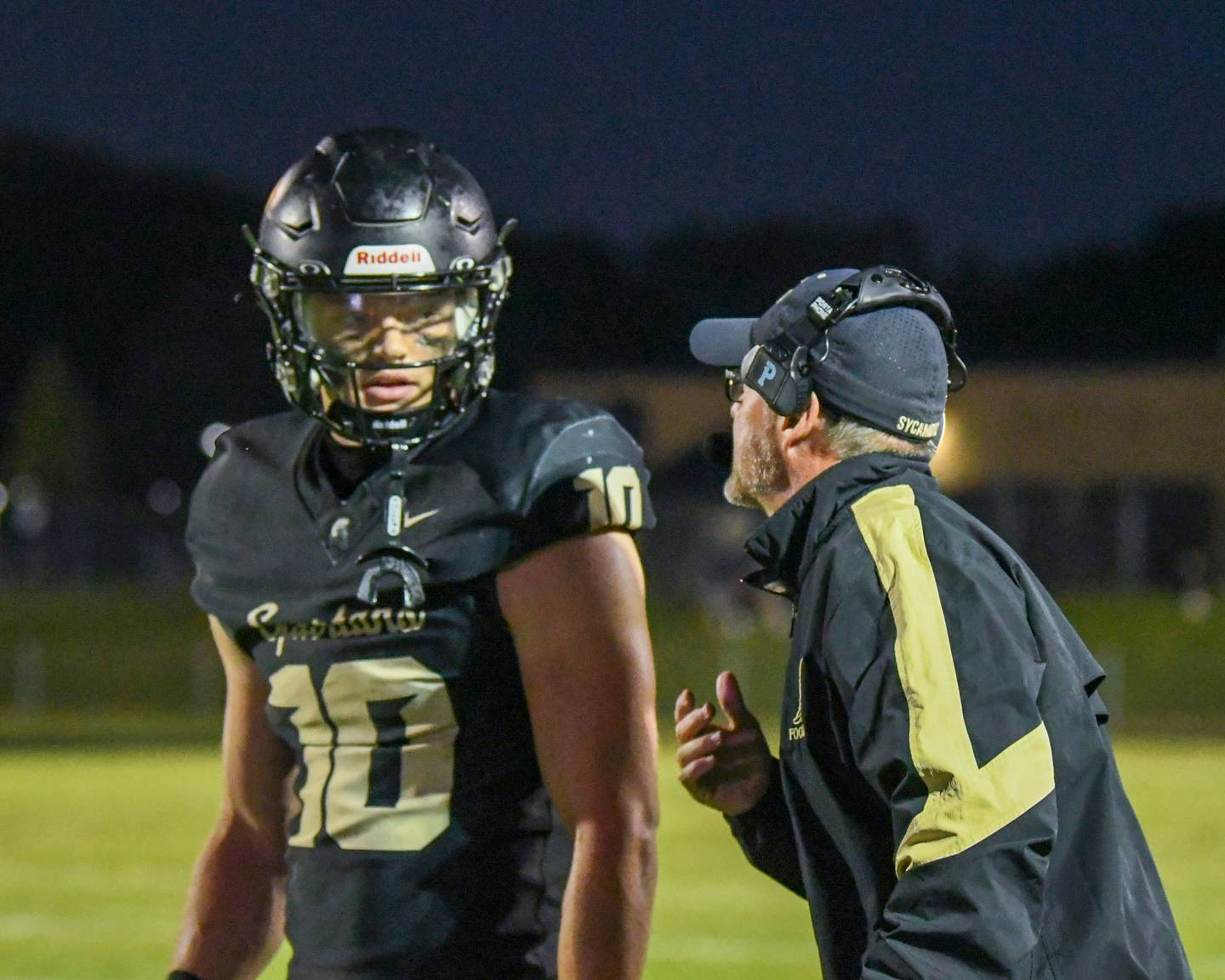 Sycamore's head coach Joe Ryan talks with Sycamore's Burke Gautcher (10) during the game on Friday Sept. 6, 2024, while taking on Oswego east held at Sycamore High School.