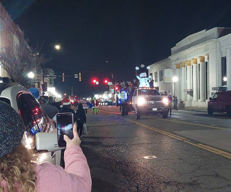 Parade goers capture the procession Saturday, Dec. 2, 2023, of the Lighted Christmas Parade in Peru.