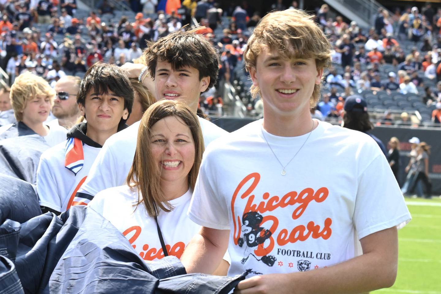 Julie Hermann, left, and her son Jack Hermann unfold the "Bear Down" flag during the Chicago Bears opening game at Soldier Field.