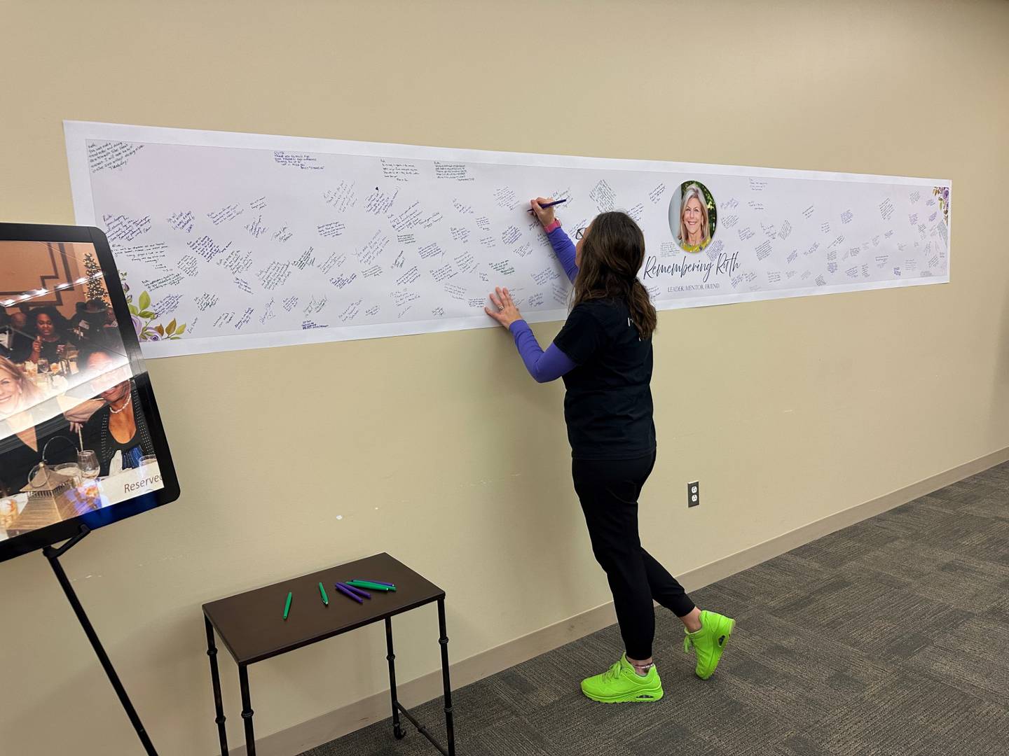 An employee signs a tribute wall for Ruth Colby, former president and chief executive officer of Silver Cross Hospital in New Lenox. Silver Cross held a celebration on Friday and Saturday to honor Colby's life and legacy.
