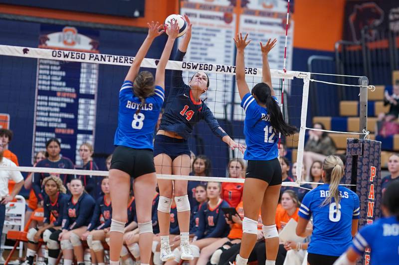 Oswego’s Mia Jurkovic (14) goes up for a kill against Rosary’s Sarah Nierman (8) and Olivia Figueras (12) during a volleyball match at Oswego High School on Tuesday, Sep 3, 2024.