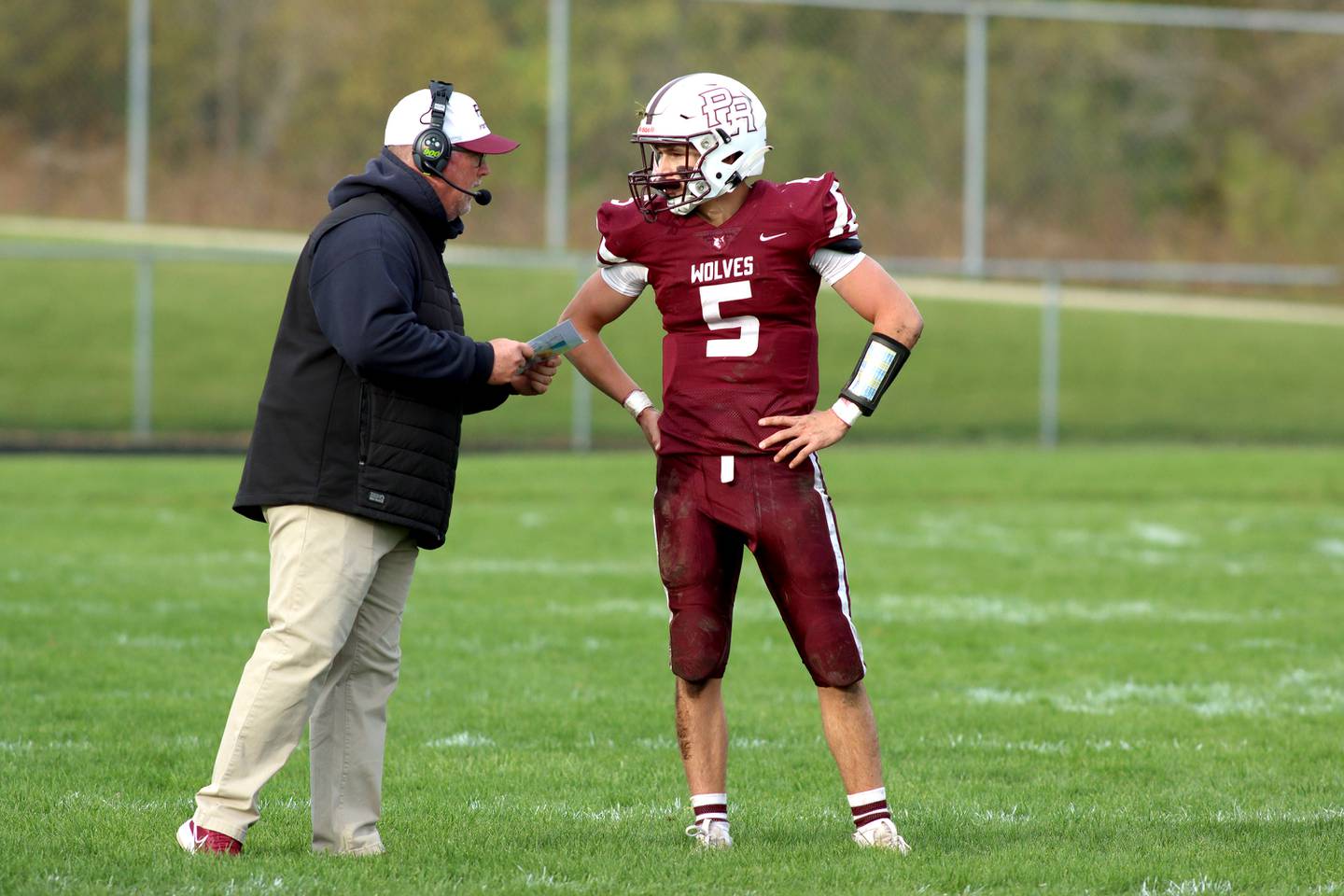 Prairie Ridge’s Head Coach Chris Schremp consults with his quarterback Joey Vanderwiel against Nazareth in first-round Class 5A playoff football action at Crystal Lake Saturday.