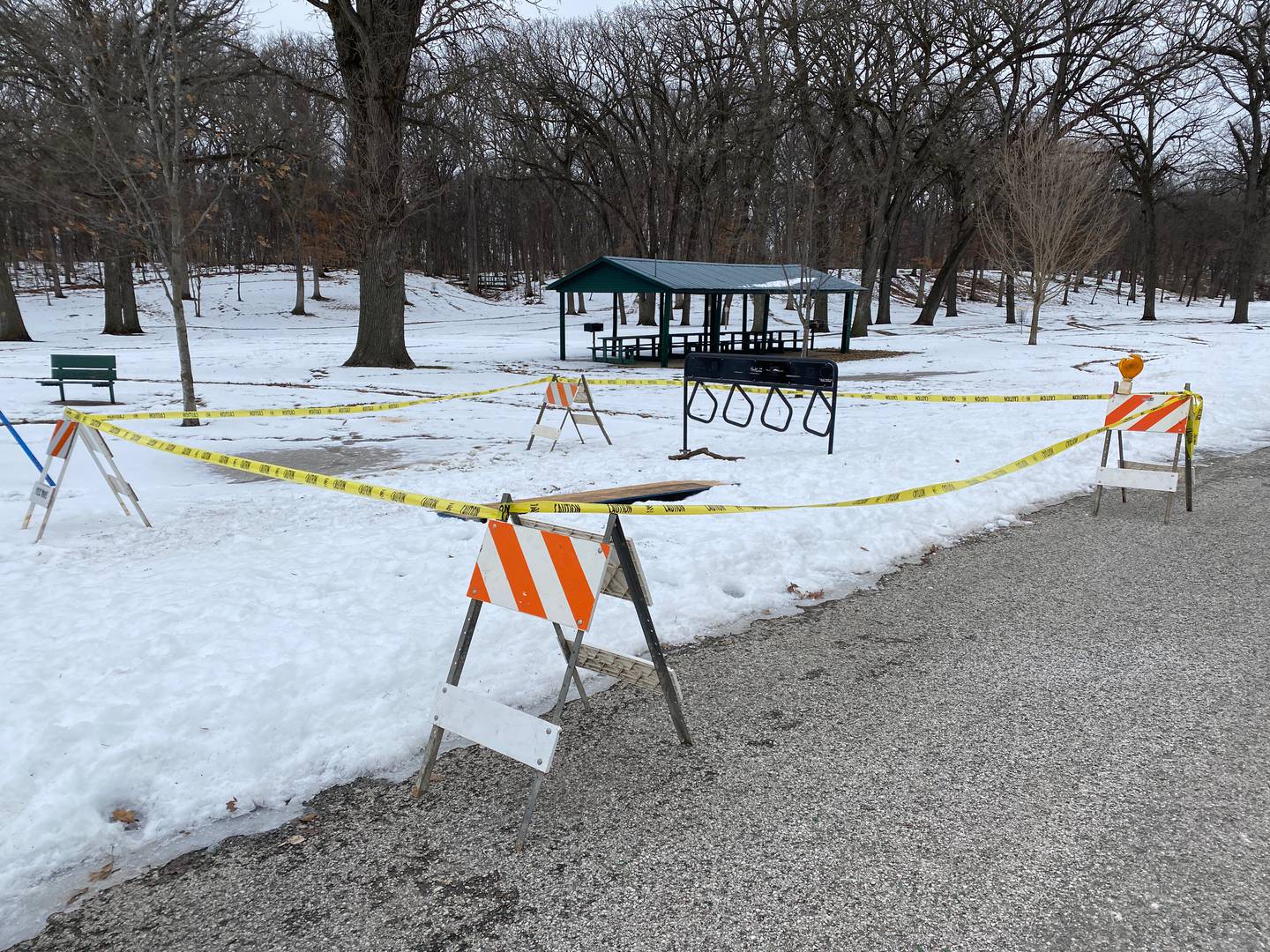 Police tape and barricades surround a sinkhole at Marilla Park in Streator. A dog started barking when it discovered another dog trapped in the sinkhole. Streator firefighters rescued the dog, Macy, who was returned to its owners who had been frantically searching for her.